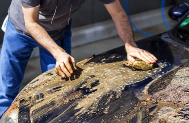 Arañando un coche con una esponja en mancha asquerosa lavado a mano lavar coche lavadero darcerapulircera.com