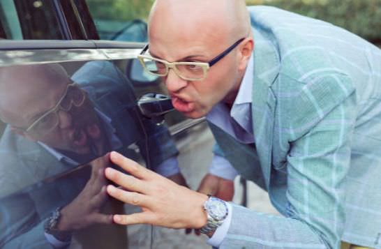 Hombre enfadado por que le han arañado el coche en un lavadero lavado a mano lavar coche darcerapulircera.com